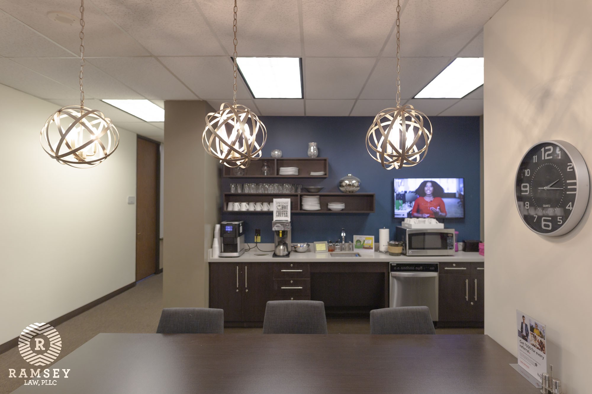 community dining/kitchen area in office table, counter, clock, TV